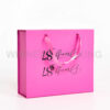 Side view of pink folding gift box with ribbon tie