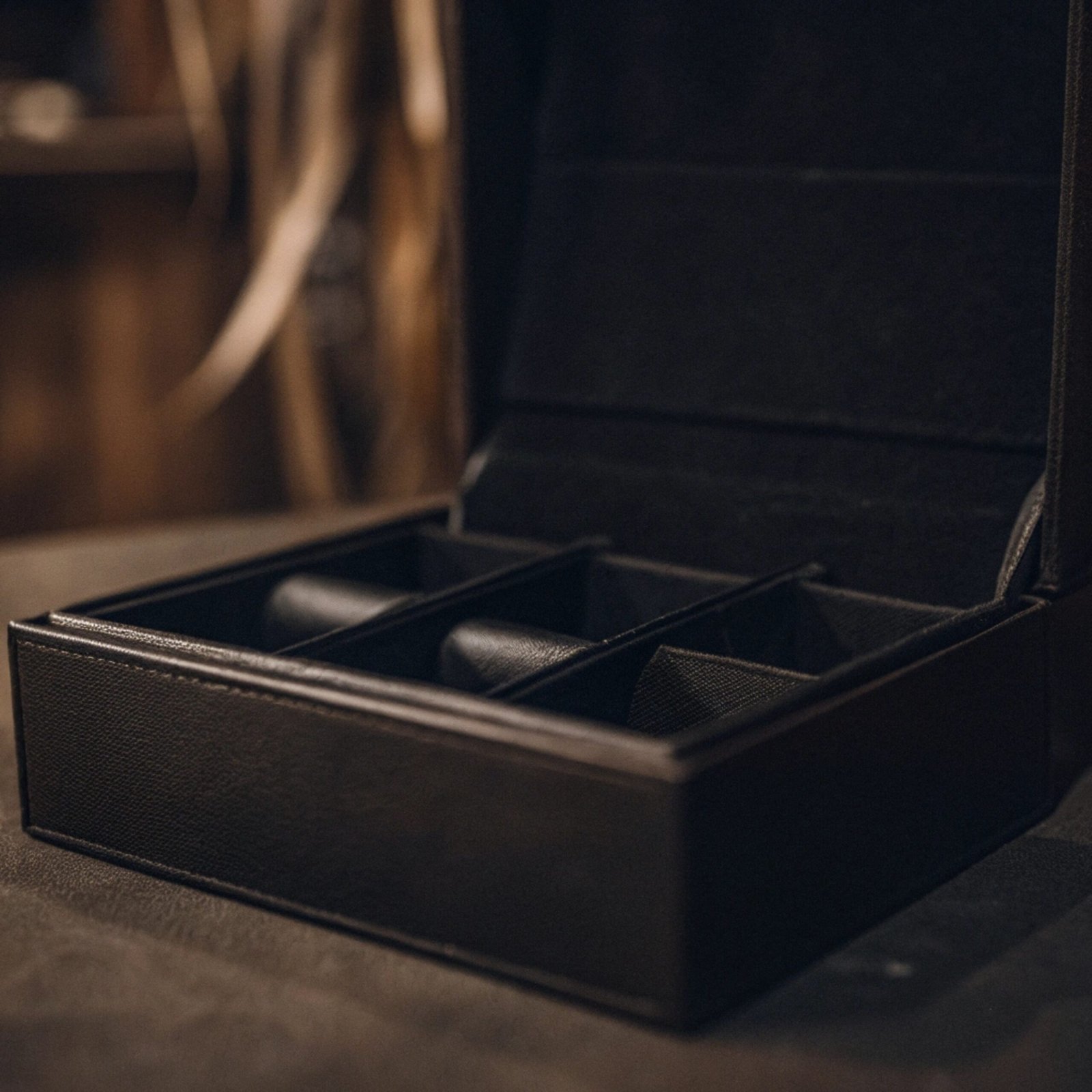 A luxurious black magnetic closure box opening to reveal a product inside