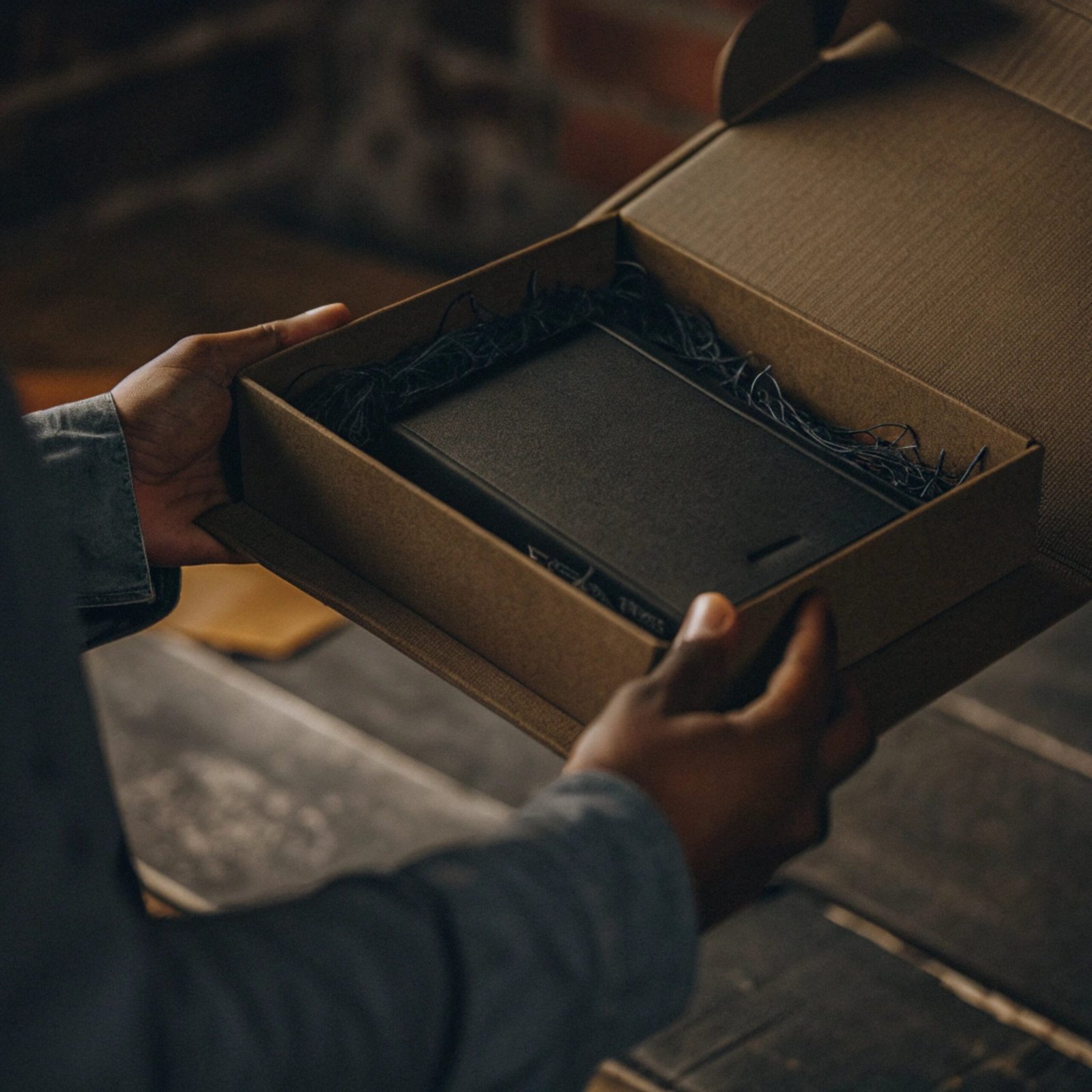A luxurious custom rigid box being opened, with soft lighting highlighting the product inside.
